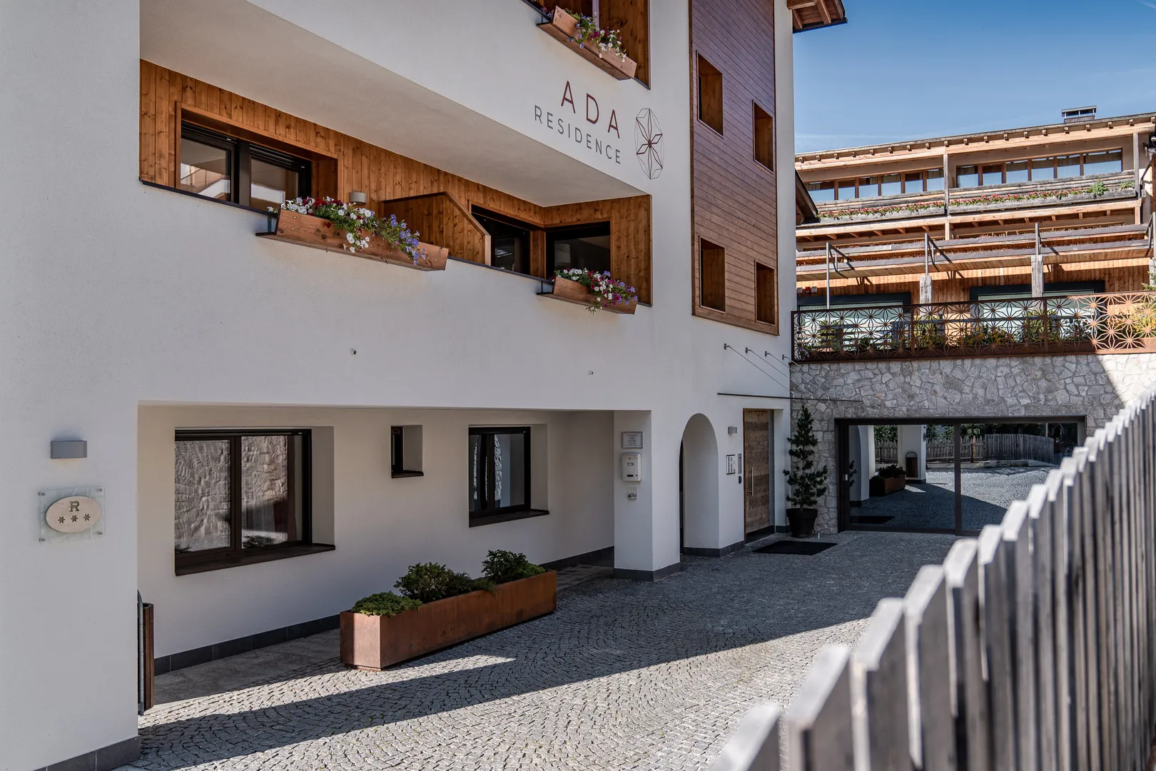 Residence Ada - cortile interno tra gli edifici con balconi fioriti