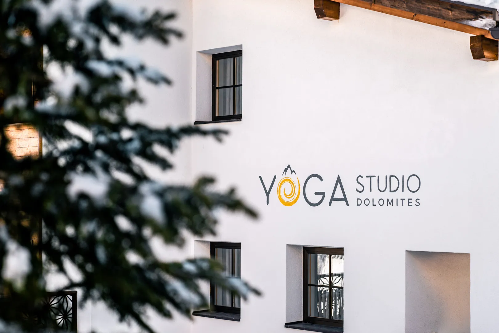 Yoga Studio Dolomites al Residence Ada - insegna tra i rami degli abeti